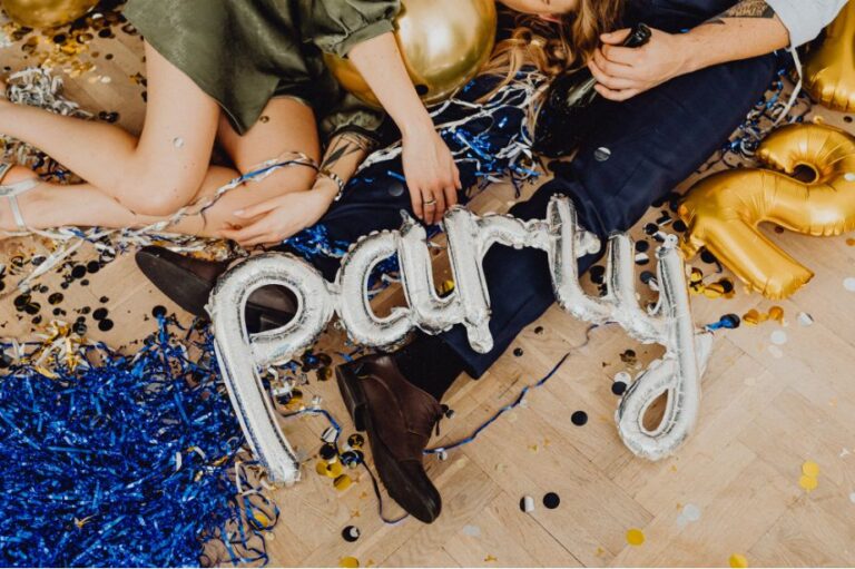 Zilveren "party"-ballon tussen confetti en serpentines