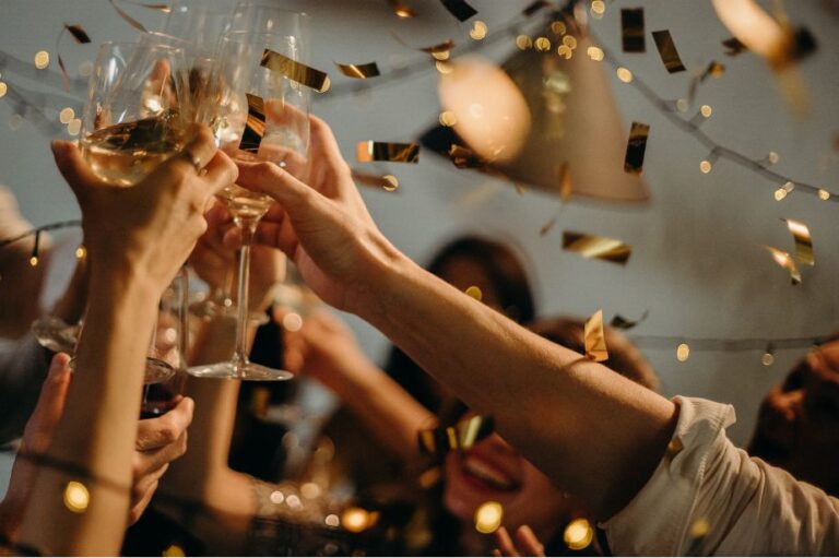 Gasten die proosten met champagne onder feestverlichting