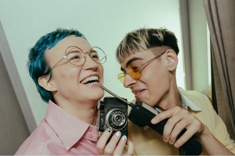 Twee vrienden die lachend foto's maken met een camera